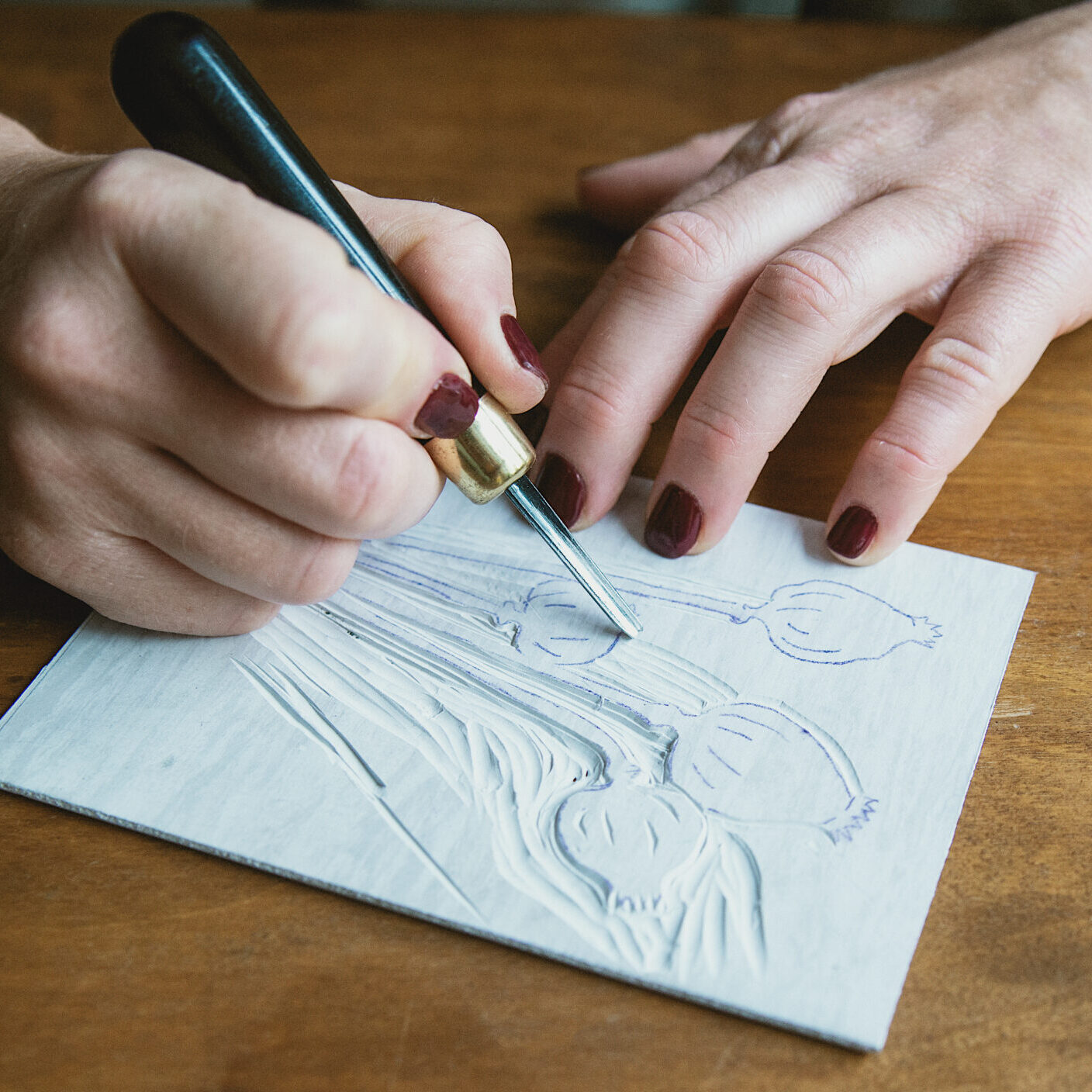 Uczestniczka warsztatów linorytu podczas wycinania wzoru