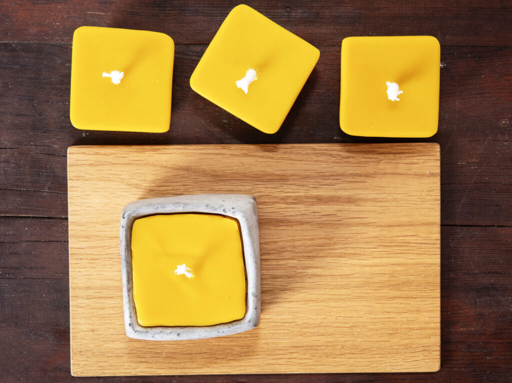 świeczka z wosku pszczelego w betonowym naczyniu